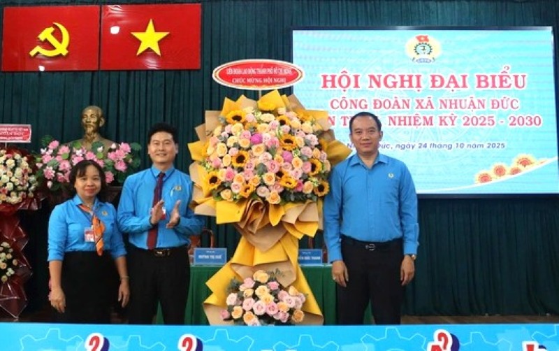 ホーチミン市労働総同盟のダン・チュン・ズン副委員長（右）が、ニュアンドゥックコミューン労働組合代表者会議に花束を贈呈した。写真: ドゥク・ロン