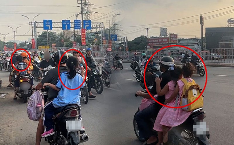 Parents carefree carry their children in the wrong direction, without wearing helmets on National Highway 13 HCMC