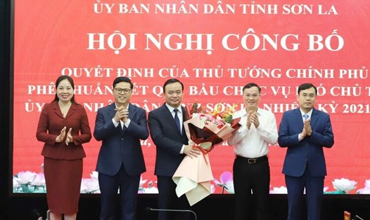 Ông Hà Trung Chiến (đứng giữa, cầm hoa) nhận quyết định phê chuẩn chức vụ Phó Chủ tịch UBND tỉnh Sơn La, nhiệm kỳ 2021 - 2026. Ảnh: Nguyễn Yến
