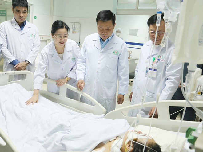 Pho Chu tich UBND tinh Nghe An Hoang Phu Hien (dung giua) cung lanh dao So Y te Nghe An tham hoi, dong vien nan nhan bi thuong do bi tan cong bang dao. Anh: Tu Thanh
