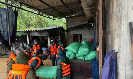 Lực lượng công an hỗ trợ người dân di tản tài sản ứng phó mưa lũ. Ảnh: T. Hồng