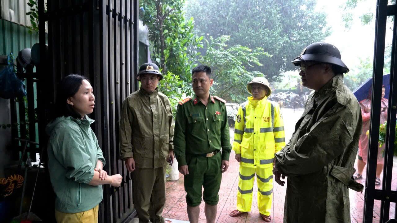 Thieu tuong Nguyen Thanh Tuan (bia phai) - Giam doc Cong an TP Hue dong vien nguoi dan vung mua lu. Anh: T. Hong.