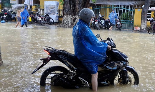 Phương tiện giao thông di chuyển trên các tuyến đường phố cổ Hội An (Đà Nẵng) liên tục chết máy khi nước lũ dâng cao. Ảnh: Thu Giang