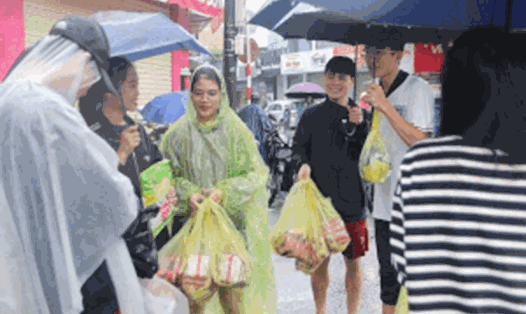 Nhóm sinh viên ở Huế đội mưa mua lương thực tiếp tế bạn bị ngập sâu trong lũ. Ảnh: Nguyễn Luân