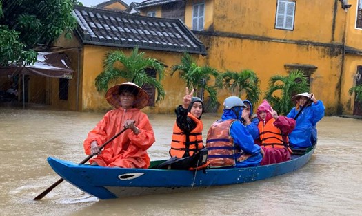Nước lũ dâng cao, người dân, du khách tại các vùng ngập sâu ở Hội An sơ tán khẩn cấp bằng thuyền. Ảnh: Thanh Huyền