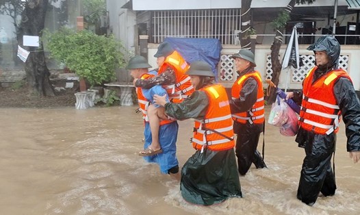 Bế cụ già 82 tuổi ra khỏi vùng ngập sâu, sơ tán dân khỏi vùng sạt lở ở Đà Nẵng. Ảnh: Mai Vy