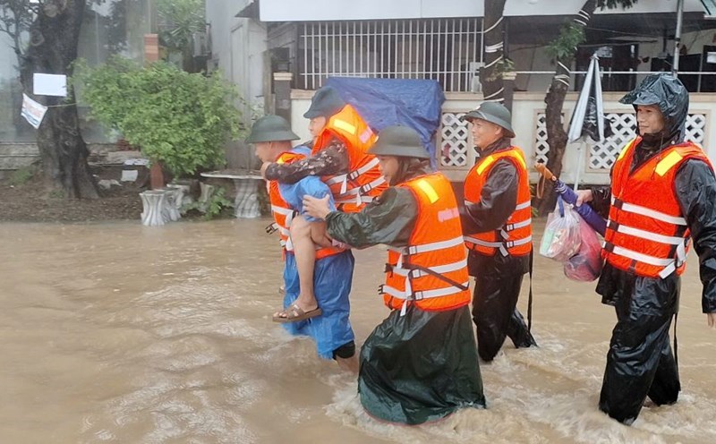 Carrying an 82-year-old man out of the deeply flooded area, evacuating people from the landslide area in Da Nang. Photo: Mai Vy