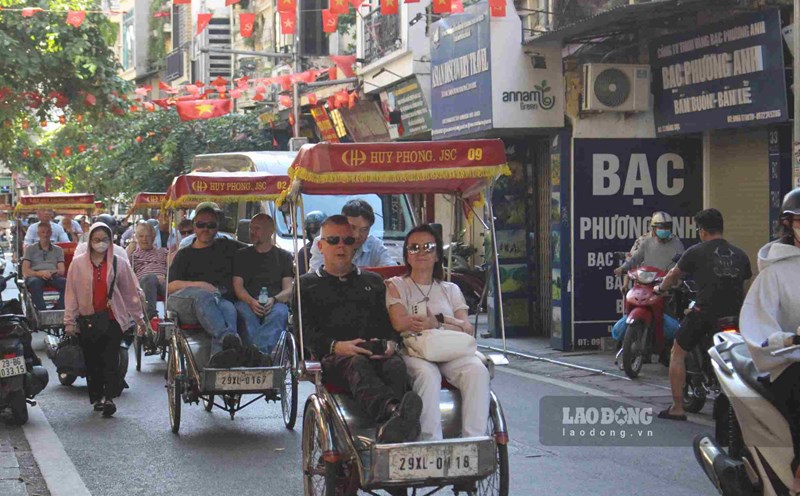 International visitors stroll around Hanoi's Old Quarter on a cyclo, enjoying the autumn weather in October. Photo: Le Tuyen