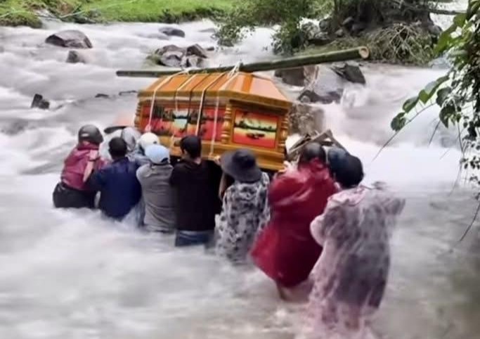 People in Tra Doc, Da Nang City struggled to carry coffins across the rough water. Photo: Truong An