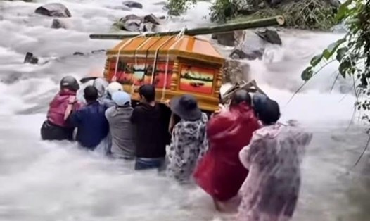 Người dân Trà Đốc, TP Đà Nẵng gồng mình khiêng quan tài vượt dòng nước dữ. Ảnh: Trường An