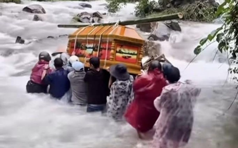 People in Tra Doc, Da Nang City struggled to carry coffins across the rough water. Photo: Truong An