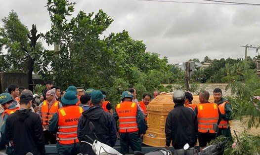 Hơn 100 cán bộ, chiến sĩ Đà Nẵng băng nước đưa linh cữu ra khỏi vùng lũ. Ảnh: Mai Vy