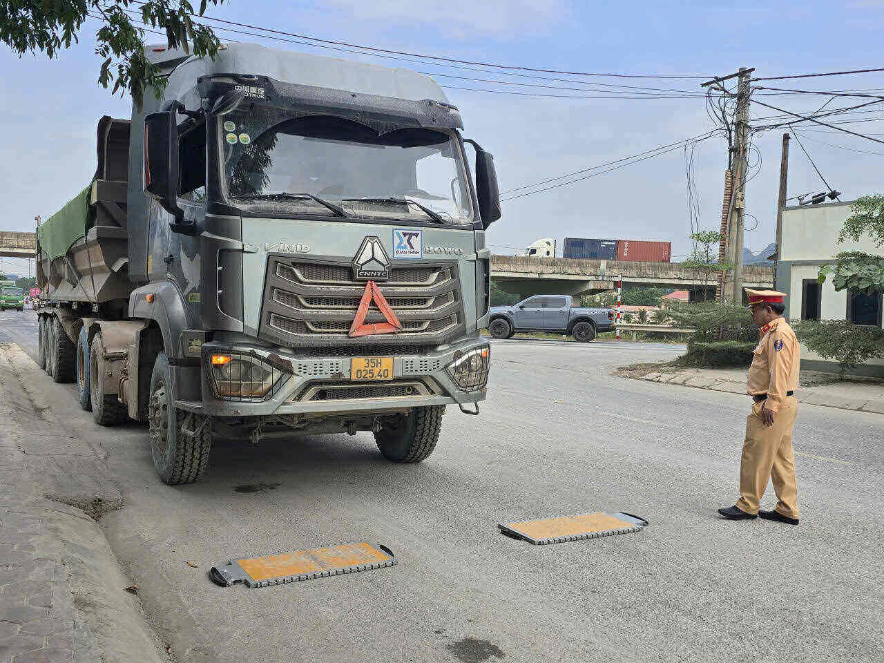 Luc luong CSGT huong dan dua xe len ban can tai trong. Anh: Nguyen Truong