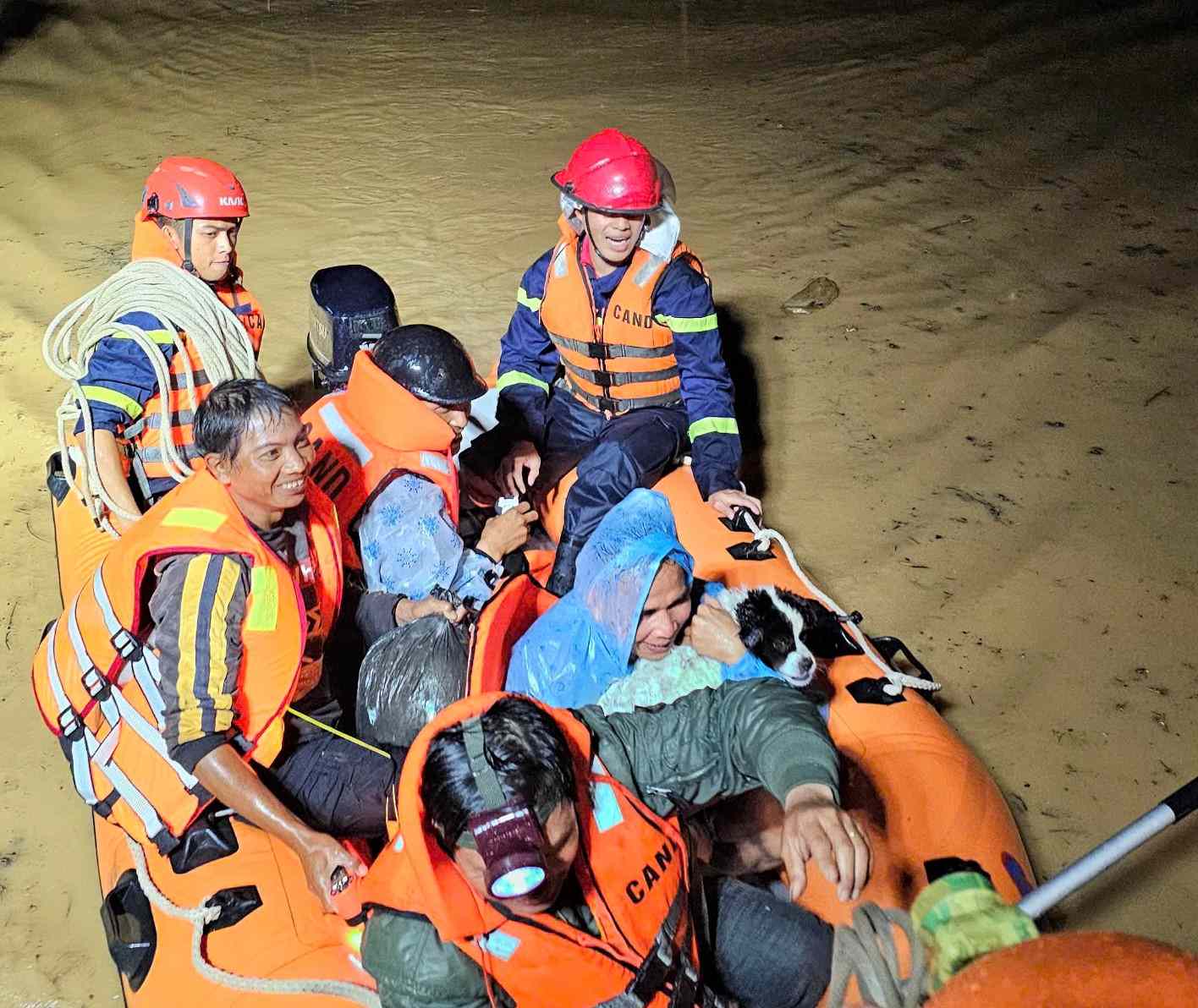 Cac luc luong dung xuong phao dua nguoi dan bi nuoc lu co lap den noi an toan. Anh: Cong an cung cap