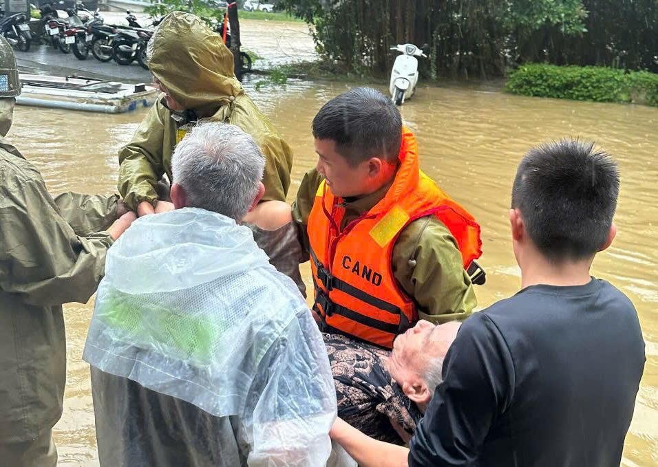 Luc luong cong an ho tro nguoi gia vung thap trung den noi an toan. Anh: T. Hong.
