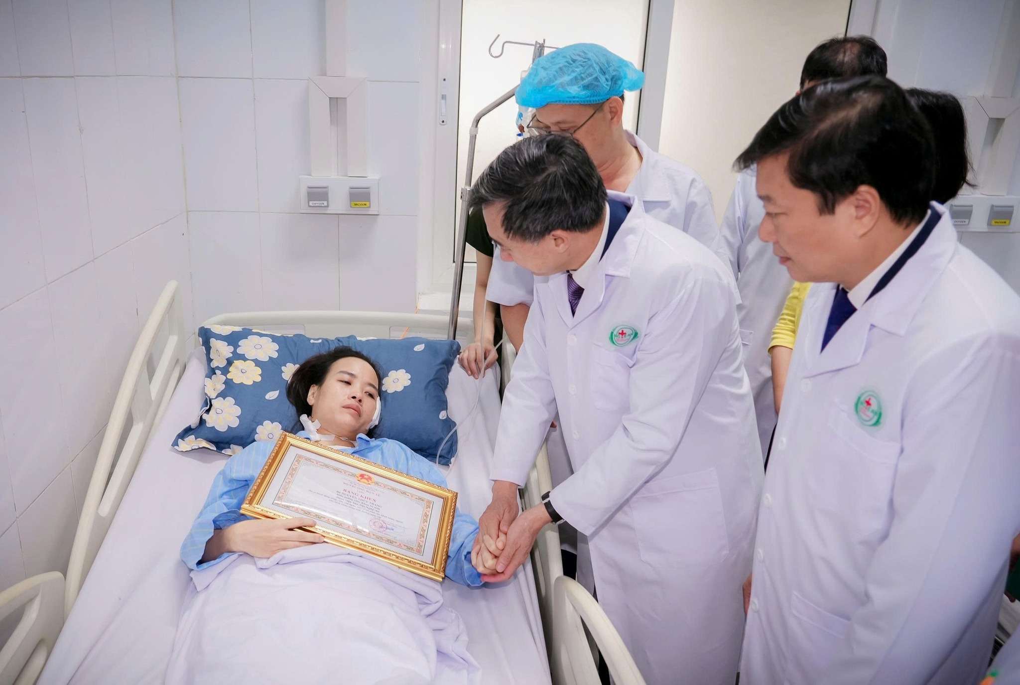 Tran Van Thuan 교수 겸 박사 보건부 차관이 Nguyen Thuy Trang 간호사에게 환자와 가족의 생명을 용감하게 보호한 공로로 보건부 장관 표창장을 수여하고 있습니다. 사진: Ngoc Anh