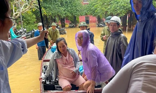 Lực lượng chức năng và đội ngũ y tế Bệnh viện Trung ương Huế kịp thời hỗ trợ thai phụ đến nơi an toàn. Ảnh: Lan Hương.