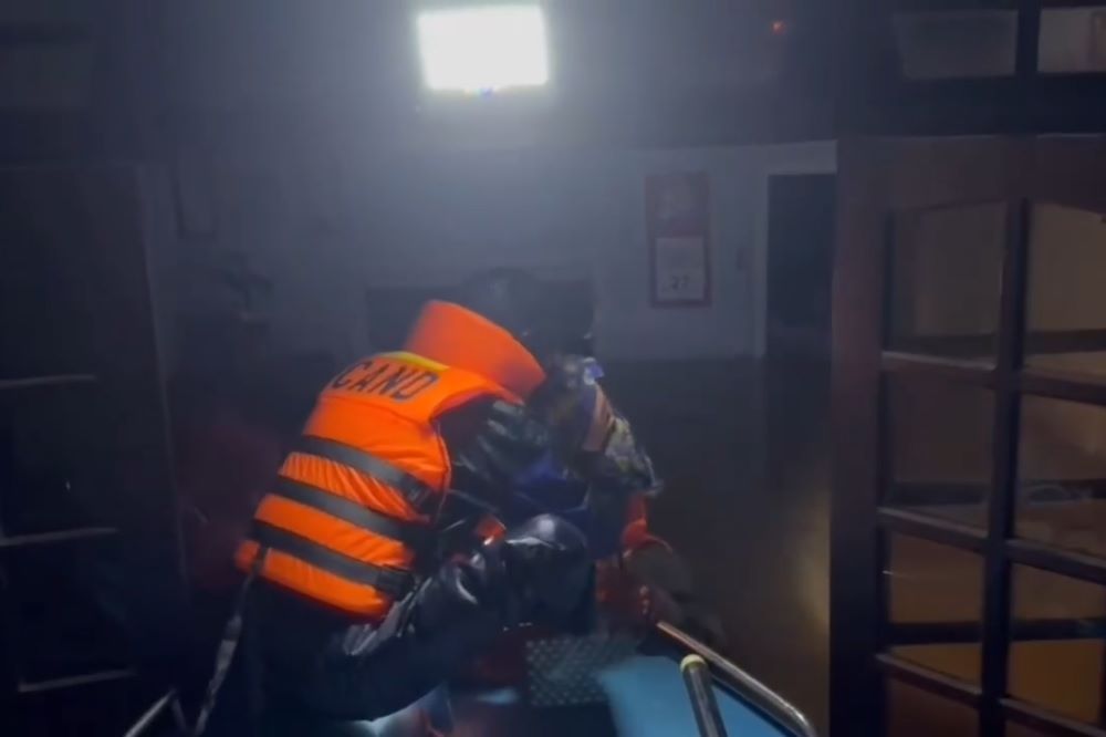 Policia de la comuna de Thuong Duc Da Nang supera las inundaciones en la noche para rescatar a 3 personas aisladas. Foto: Mai Vy