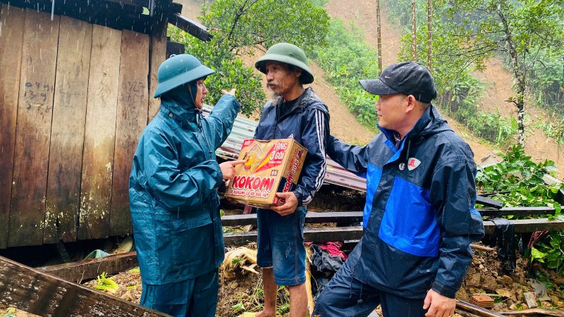 Lanh dao xa Tra Tan, TP. Da Nang dong vien, ho tro nhu yeu pham cho cac ho dan bi lu cuon troi nha. Anh: Truong An