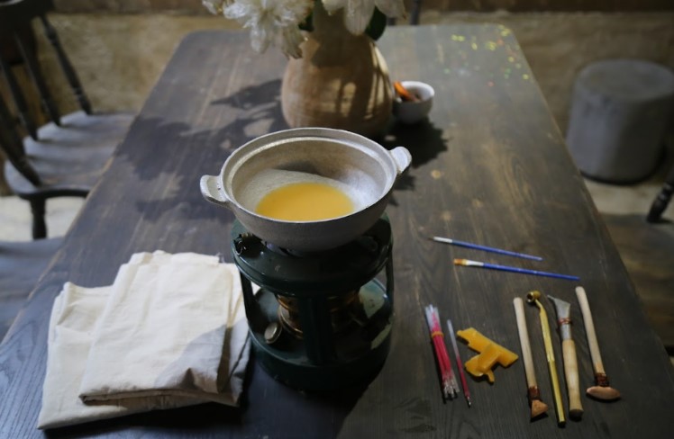 Dung cu ve sap ong, noi nau sap va nhung tam vai trang tinh duoc nghe nhan chuan bi san sang cho buoi trai nghiem.