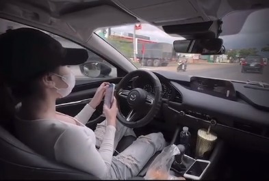 The police are clarifying the case of a woman letting go of both hands to drive and surfing her phone while participating in traffic. Photo: Bao Trung