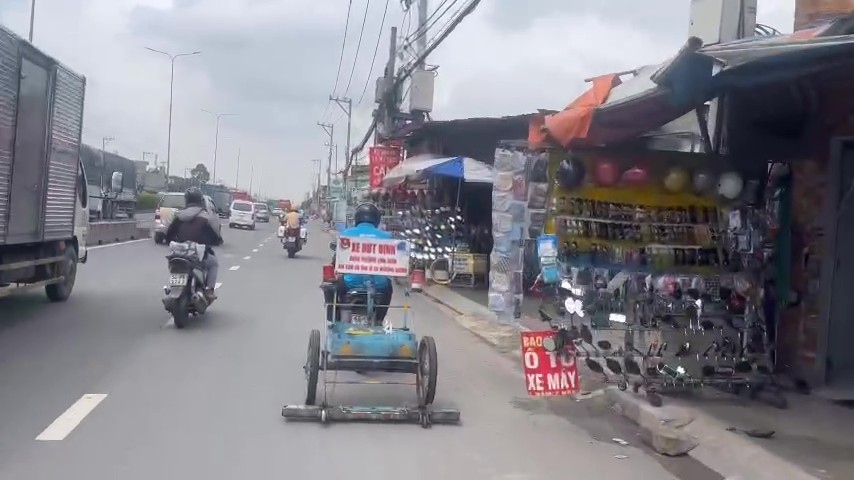 CSGT phoi hop doi tinh nguyen tien hanh hut dinh, vat sac nhon tren Quoc lo 1 (nay la duong Do Muoi, phuong An Phu Dong). Anh: PC08