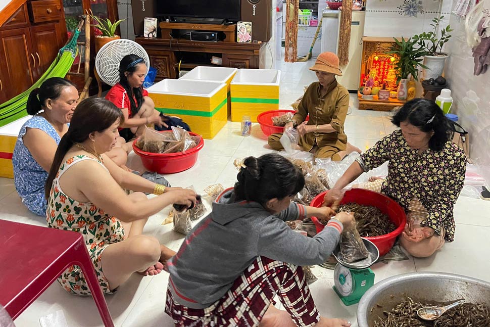 Nguoi dan xa dao Nhon Chau dong goi ca com rim gui cho ba con vung ngap lut. Anh: Dinh Truong