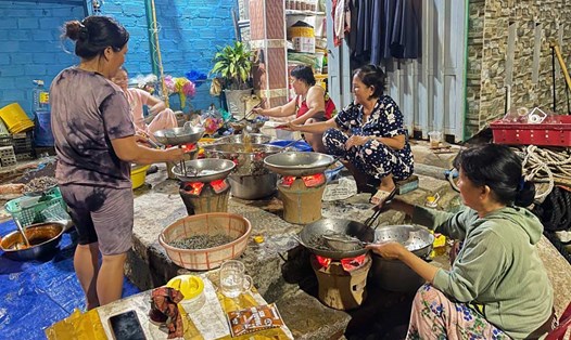 Người dân xã đảo Nhơn Châu (Gia Lai) rim cá cơm, gửi tặng bà con vùng ngập lụt miền Trung. Ảnh: Đình Trương