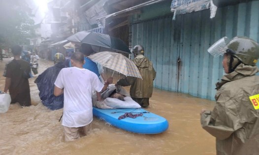 Lực lượng công an đem người già đi cấp cứu. Ảnh: T. Hồng.
