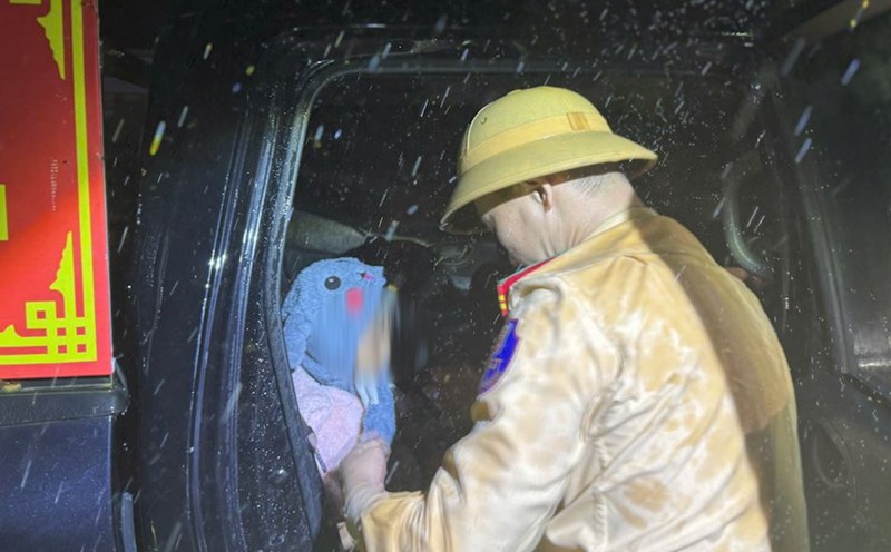 Throughout the night rescuing people in flooded areas, Da Nang Traffic Police canoe-travel a child with high fever to the emergency room. Photo: Tran Thi