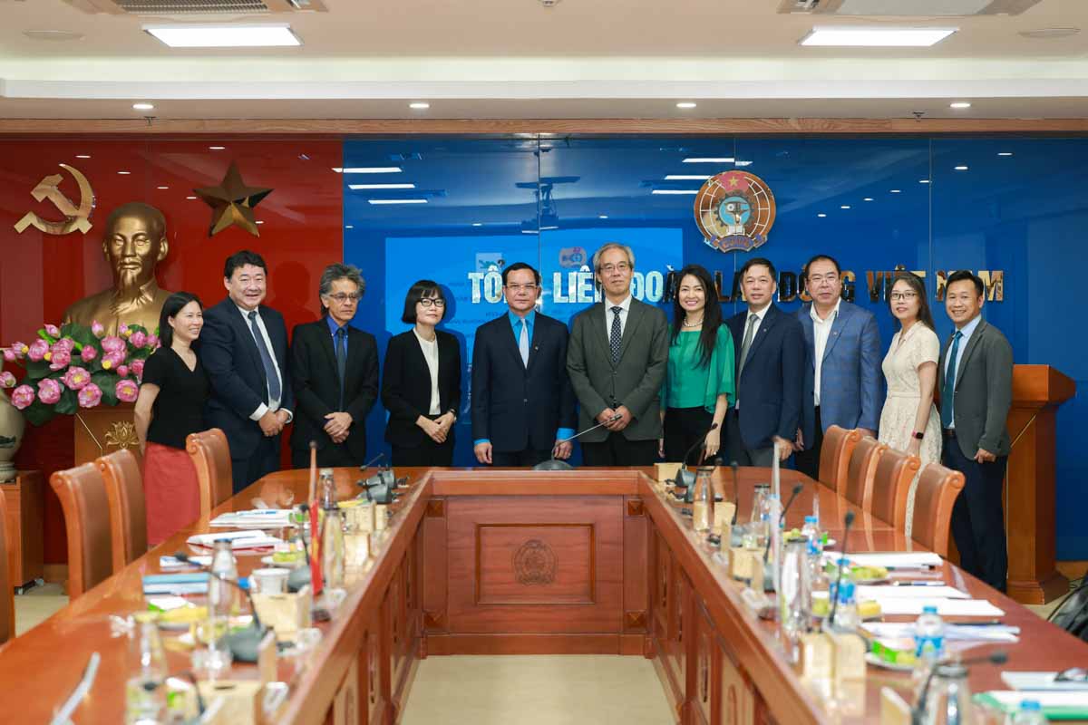 ベトナム労働総同盟のグエン・ディン・カン委員長と日本労働組合総連合会の秋山正臣委員長が会談に出席した代表者らと写真撮影。写真: ハイ・グエン