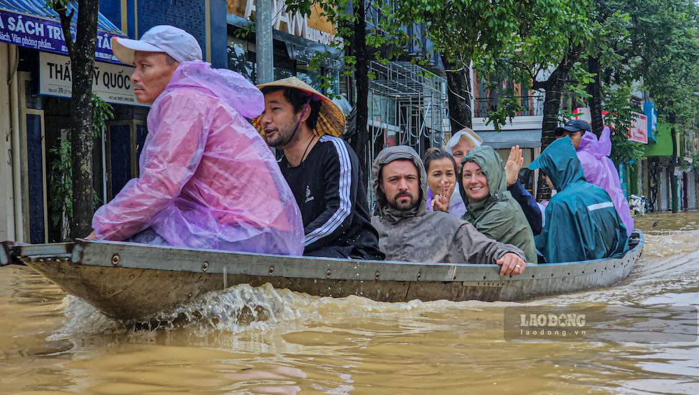 Foreign tourists had to rent a boat to transport their luggage to evacuate when floods rose in Hue. Photo: Nguyen Luan