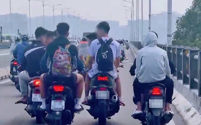 A group of young men without helmets drove in line on Vinh Tuy Bridge. Photo cut from clip