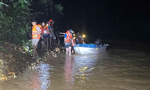 Người dân được lực lượng cứu hộ dùng thuyền đưa ra khỏi vùng nước lũ chảy xiết. Ảnh: Công an Quảng Trị