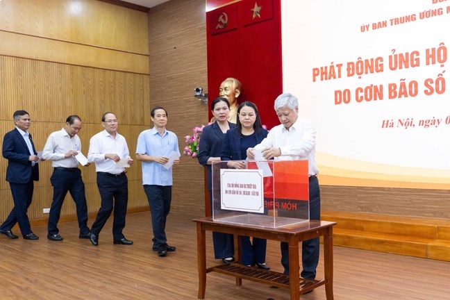El miembro del Buro Politico el Secretario General del Partido el Presidente del Comite Central del Frente de la Patria de Vietnam Do Van Chien y los delegados apoyan a los compatriotas afectados por la tormenta numero 10. Foto: Quang Vinh
