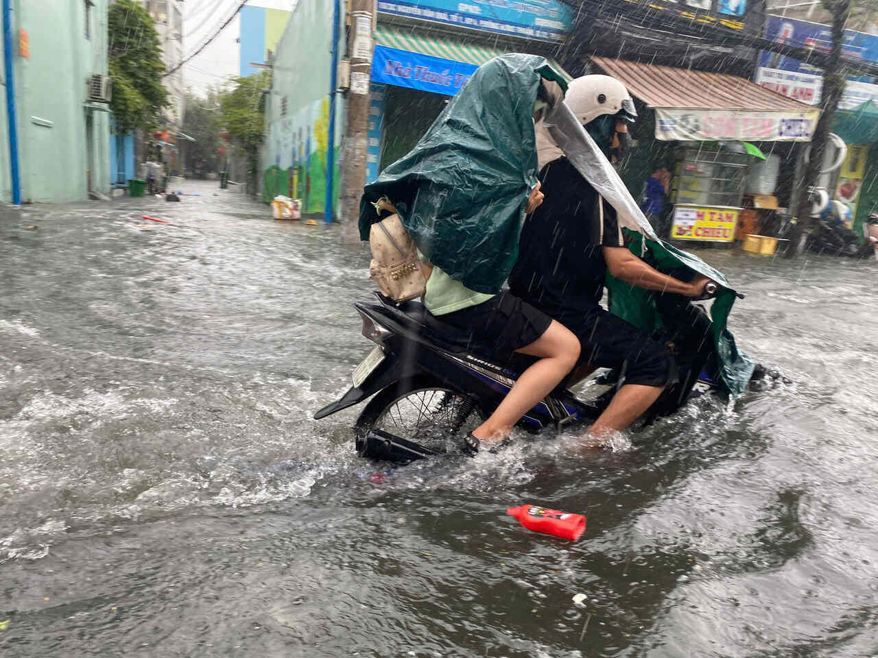 Nguoi dan chay xe may trong dong nuoc ngap gan nua banh xe giua con mua xoi xa trua 3.10 tai TPHCM. Anh: Anh Tu
