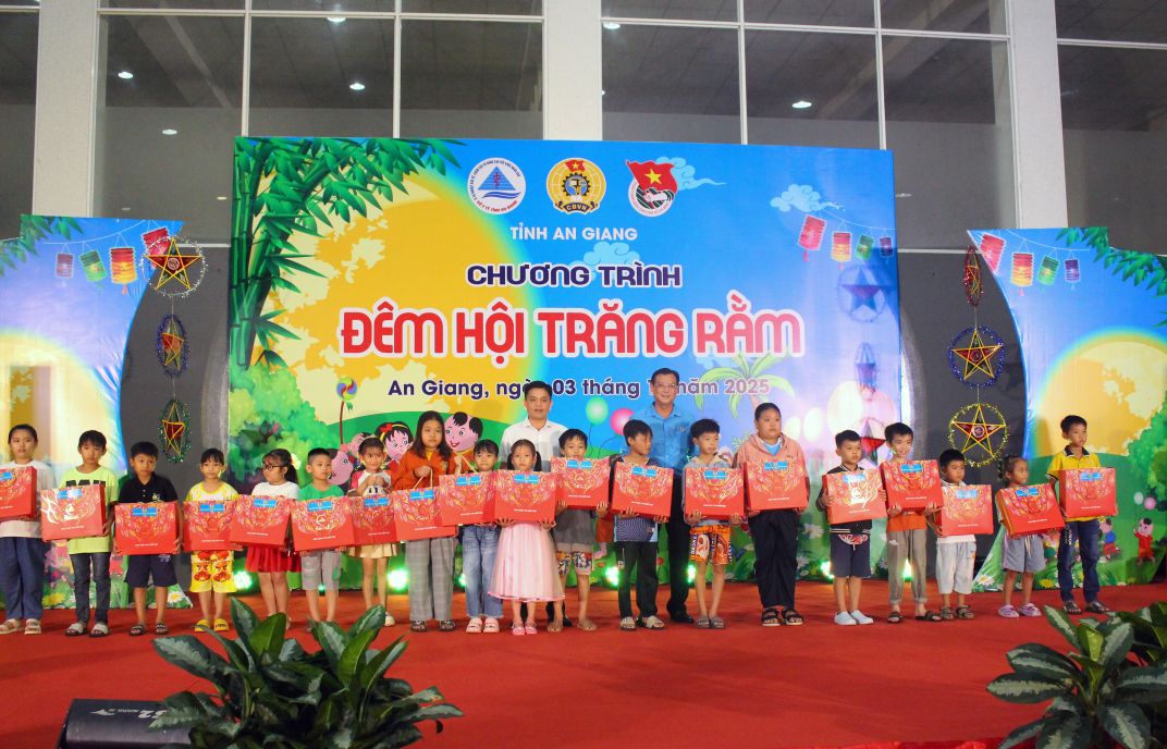 Ong Nguyen Huu Ngoc - Pho Truong Ban Tuyen giao Dan van va Tinh uy va ong Nguyen Nhat Tien phat qua cho cac chau thieu nhi tren san khau. Anh: Thanh Mai