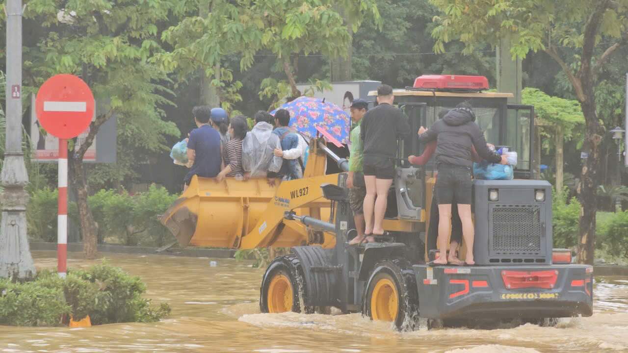 Nguoi dan di chuyen qua duong ngap bang xe co gioi trong sang 30.10. Anh: Nguyen Luan.