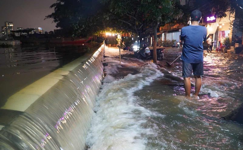 High tide, water overflows Thanh Da embankment causing flooding. Photo: Thai Bao