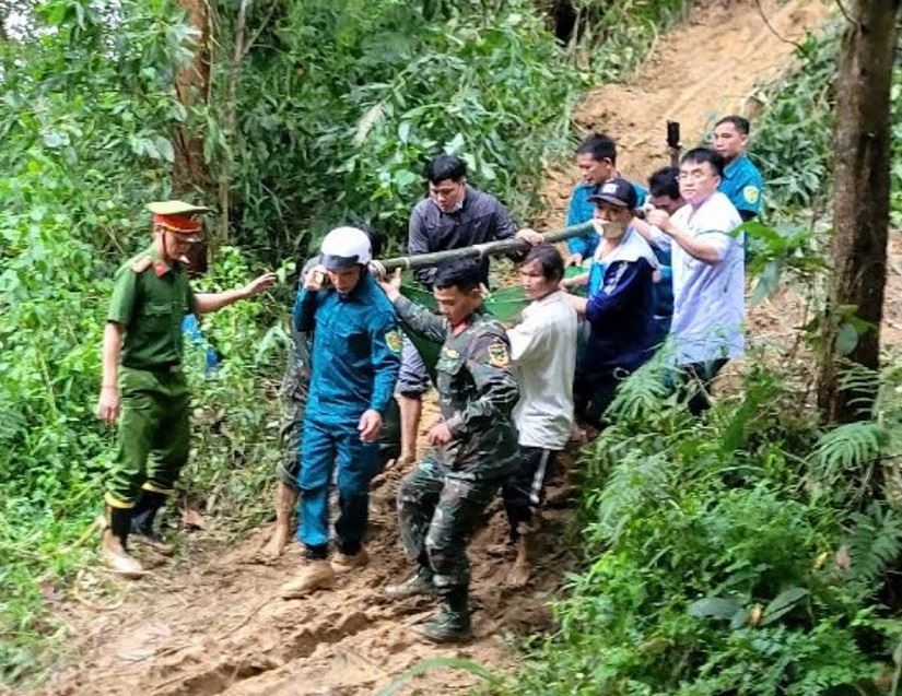 The authorities coordinated with doctors and nurses at Son Tay Medical Center, Quang Ngai province to carry pregnant woman D. through the forest, crossing the landslideed road. Photo: Minh Dan