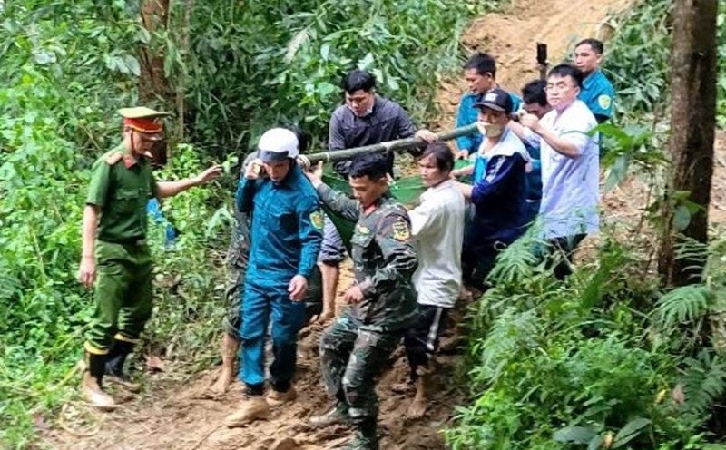 The authorities coordinated with doctors and nurses at Son Tay Medical Center, Quang Ngai province to carry pregnant woman D. through the forest, crossing the landslideed road. Photo: Minh Dan