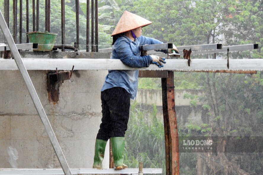 Mot cong nhan dang gia co cac khung sat thep xung quanh tru cau. Anh: To Cong.