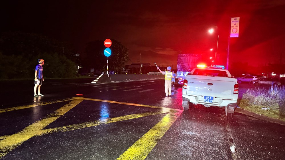 Canh sat Giao thong tuc truc huong dan cac phuong tien di duong khac do ngap tren Quoc lo 1. Anh: Duy Tuan