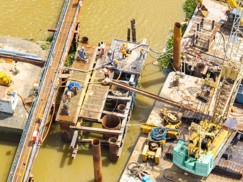 Tai cong truong, cac nha thau dang khoan coc va do be tong mong tru giua long song. Day la buoc ky thuat dau tien cua hang muc mo rong cau. Ảnh: Nham Nguyen