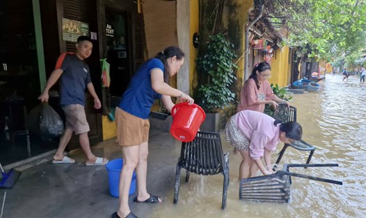 Nhiều người dân Hội An đang tất bật dọn nhà khi mực nước lũ rút nhanh. Ảnh: Thu Giang