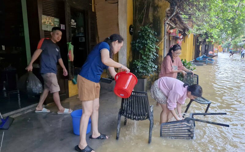 Muchos residentes de Hoi An estan ocupados limpiando sus casas cuando el nivel del agua de la inundacion retrocede rapidamente. Foto: Thu Giang