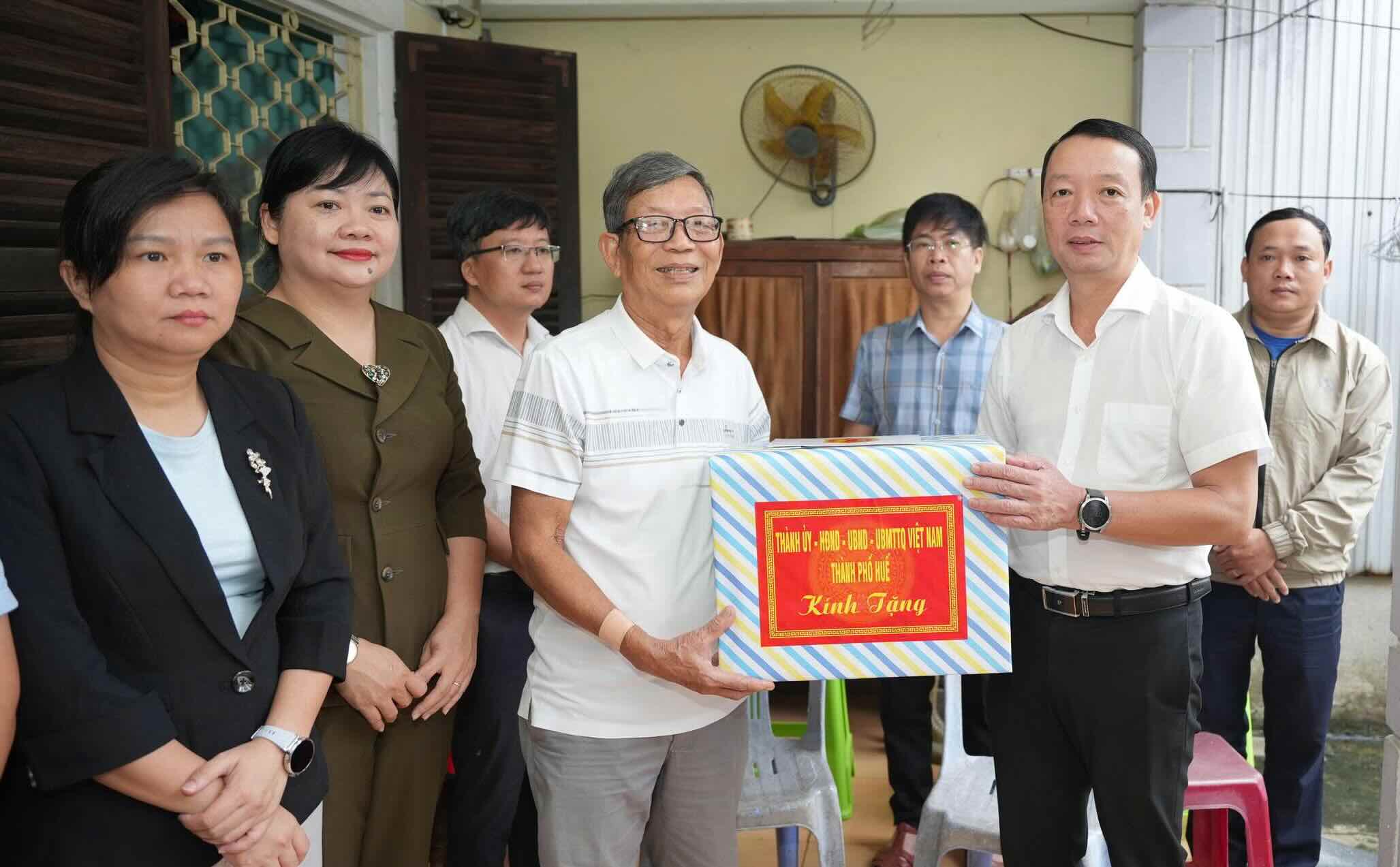 Chu tich UBND TP Hue Phan Thien Dinh an can tham hoi suc khoe, tang qua tri an gia dinh chinh sach. Anh: N. Hieu.