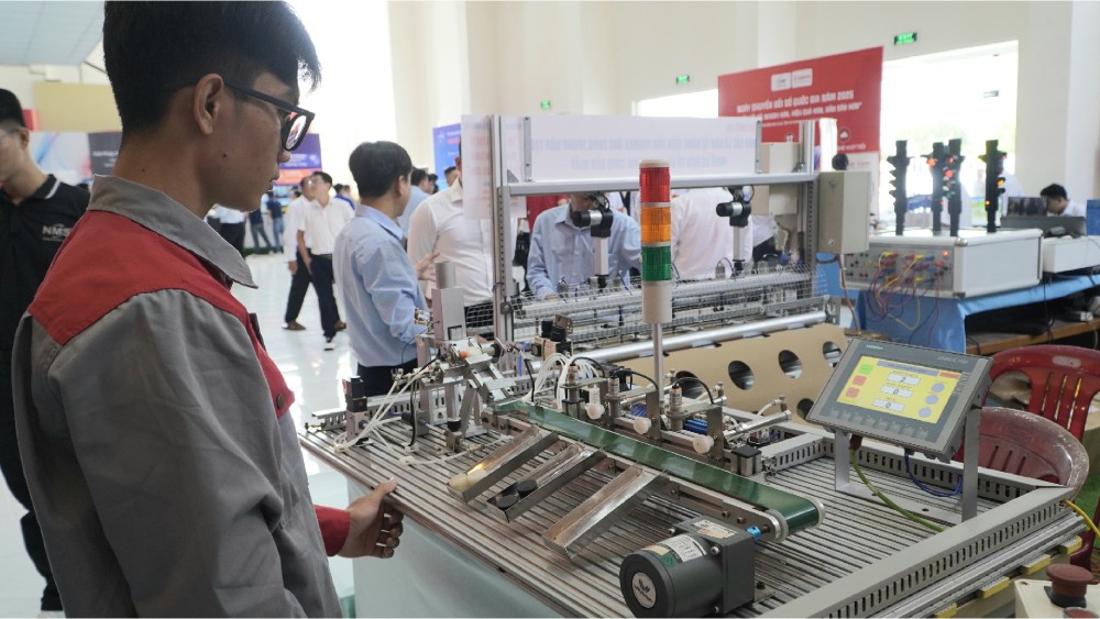 Mo hinh thiet bi phan loai san pham bang bang chuyen thay doi van toc cua truong Cao dang Nghe An Giang trung bay tai hoi thao. Anh: Nguyen Anh