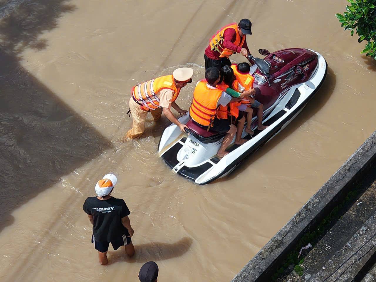 Lam Dong Traffic Police used a canoe to cross the flood to rescue people. Photo: Phuc Khanh