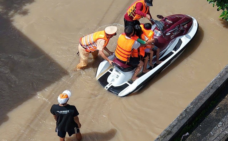 Lam Dong Traffic Police used a canoe to cross the flood to rescue people. Photo: Phuc Khanh